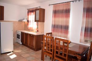a kitchen with a table and chairs and a refrigerator at Villa Ostria in Alonnisos Old Town