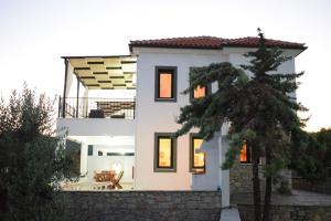 a white house with a tree in front of it at Villa Ostria in Alonnisos Old Town +1 photo