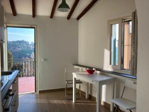 a kitchen with a table and a view of a balcony at piccolo appartamento in Montescudaio in Montescudaio