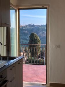 a kitchen with a door open to a balcony at piccolo appartamento in Montescudaio in Montescudaio