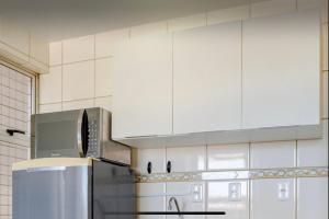a kitchen with white cabinets and a refrigerator at LOFT no Centro de Campos Novos in Campos Novos