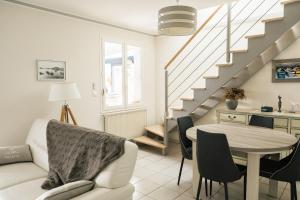 a living room with a table and a staircase at Evasion familiale à la plage in Trégastel