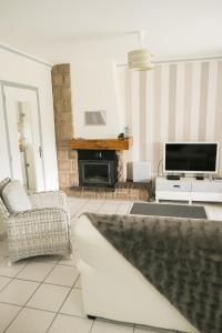 a living room with a fireplace and a tv at Evasion familiale à la plage in Trégastel