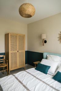 a bedroom with a bed and a cabinet and a chandelier at Evasion familiale à la plage in Trégastel