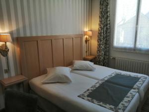 Postel nebo postele na pokoji v ubytování Hôtel Les Fleurs