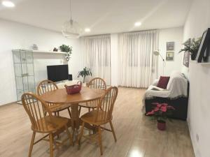 a living room with a wooden table and chairs at Suites Esencia Atlántica Confort cerca del mar in Telde