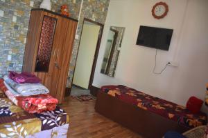 a room with two beds and a flat screen tv at Mountain Retreat Ecostay in Kalimpong