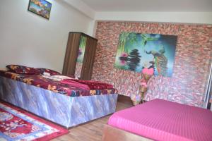 a room with a bed and a painting on the wall at Mountain Retreat Ecostay in Kalimpong +35 photos