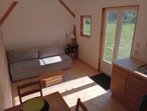 a living room with a couch and a table at Tiny house sous le chene in Saint-Roch