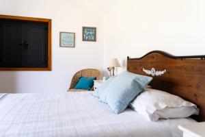 a bedroom with a bed with blue and white pillows at Casa da Colina in Amarante