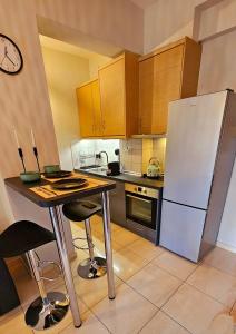 a kitchen with a table and a white refrigerator at OLD TOWN 58a in Xanthi