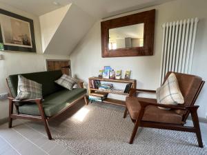 a living room with two chairs and a mirror at The Old Stable at Manor House, Middleton in Middleton