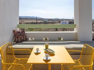 米科利维亚Plioni Villas With Private Pool & Suites With Hot Tub的一间有桌子、椅子和窗户的房间