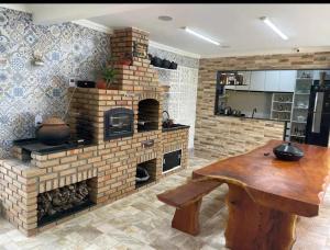 a kitchen with a brick fireplace and a wooden table at Temporada2 in Olinda