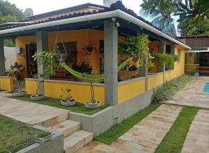 a yellow house with potted plants in front of it at Temporada2 in Olinda