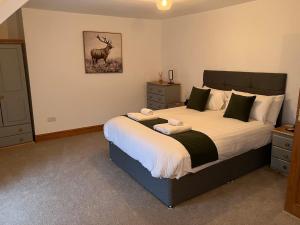 ein Schlafzimmer mit einem großen Bett mit einem Hirschbild an der Wand in der Unterkunft Hideaway Cottage in Troedyraur