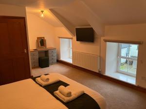 ein Schlafzimmer mit einem Bett, auf dem zwei Handtücher liegen in der Unterkunft Hideaway Cottage in Troedyraur