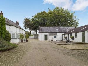 eine unbefestigte Straße zwischen zwei weißen Gebäuden mit Bäumen in der Unterkunft Hideaway Cottage in Troedyraur