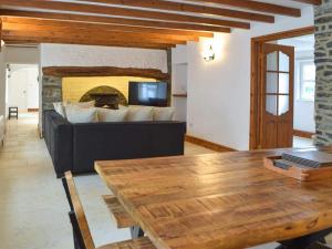 ein Wohnzimmer mit Tisch und Kamin in der Unterkunft Hideaway Cottage in Troedyraur