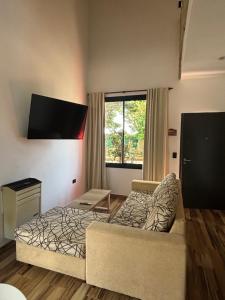a living room with a couch and a bed at Cabaña La Arianna in Santa Teresita