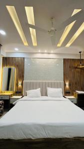 a bedroom with a large white bed and a television at Leisure homes in Lucknow +4 photos