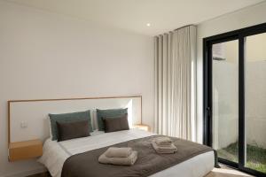 a bedroom with a large bed with two towels on it at Marco 4 Seasons- Winter in Arco da Calheta