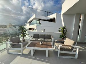 a balcony with a table and chairs on a building at J&J Luxury Apartments in Estepona