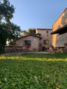 a building with a yard with yellow flowers in front of it at Domaine de La Michelle in Madaillan