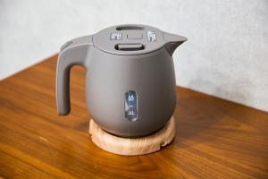 a tea kettle sitting on a wooden cutting board at ルチル池袋東京 in Tokyo