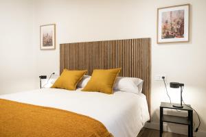 a bedroom with a large bed with yellow pillows at Casa Rural Lucera Bardenas in Valtierra