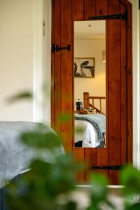 a mirror reflecting a bed in a bedroom at Mulberry Cottage in Beckford