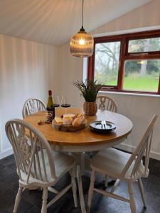 a table with a plate of bread and wine glasses at Mulberry Cottage in Beckford
