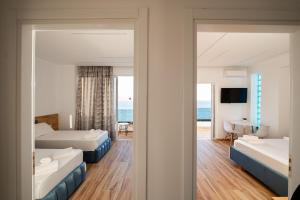 a hotel room with two beds and a view of the ocean at Vila Amare in Sarandë