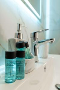 a bathroom sink with two bottles of moisturizers on it at Vila Amare in Sarandë +88 photos