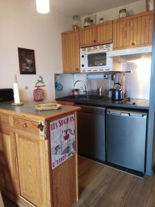 una cocina con fregadero y estufa horno superior en Les Eglantines studio non adapté aux personnes avec des difficultés physiques, en Bolquere Pyrenees 2000