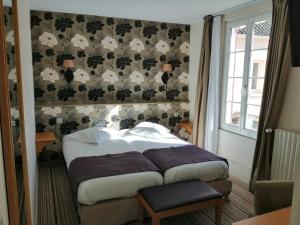 Postel nebo postele na pokoji v ubytování Hôtel Les Fleurs
