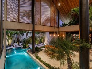 un patio interior con piscina y palmeras en Villa Levante Bali by House of Winds - Tropical Oasis near Canggu, en Kerobokan