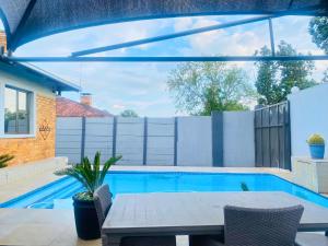 a patio with a table and a swimming pool at Saho Guesthouse in Vanderbijlpark