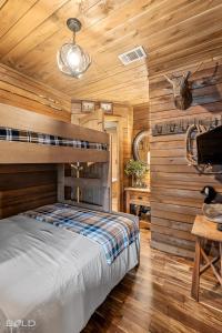 Un dormitorio con una cama en una habitación con paredes de madera. en Hot Tub, Emerald Isle Log Cabin, Lake Front, en Shreveport
