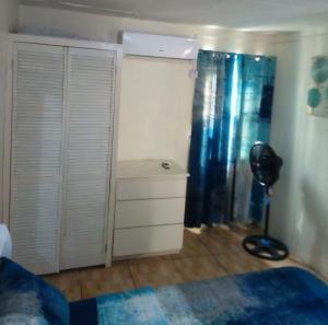 una camera con letto e scrivania con ventilatore di The Cupid Chalet a Belmont
