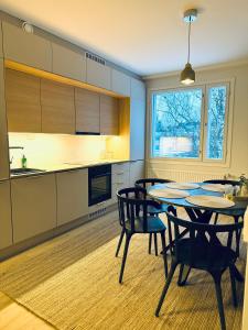 a kitchen with a table and chairs in a room at Modern and elegant three-room cityhome in Jyväskylä