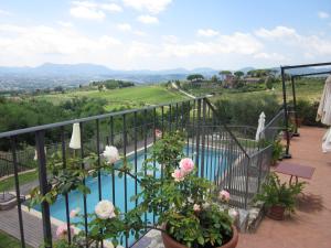 einen Balkon mit Blick auf den Pool und die Blumen in der Unterkunft Tenuta San Pietro Luxury Hotel in Lucca