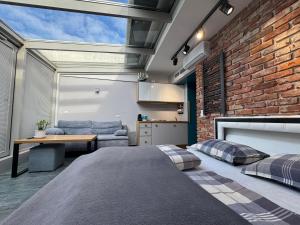 Un dormitorio con una pared de ladrillo y una cama. en TOP VIEW SKY & SEA- Maloves Władysławowo - Prywatny apartament na wynajem -widok na morze ,taras ,aneks, en Władysławowo