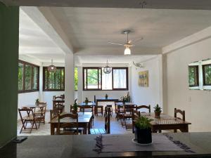 a dining room with tables and chairs and windows at DORM Olhar da Sereia in Arraial d'Ajuda