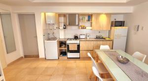 eine Küche mit einem weißen Kühlschrank und einem Tisch mit Stühlen in der Unterkunft Brescia departamentos in San Isidro + 1 Foto