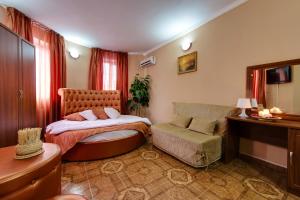 1 dormitorio con cama, silla y escritorio en Marton Lion Krasnodar, en Krasnodar