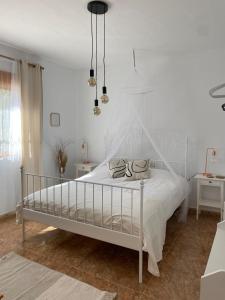 una camera da letto bianca con un letto bianco e due tavoli di Maison typique avec vue dégagée sur la vallée a Fortuna