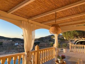 una veranda con soffitto in legno e tavolo con tenda di Maison typique avec vue dégagée sur la vallée a Fortuna