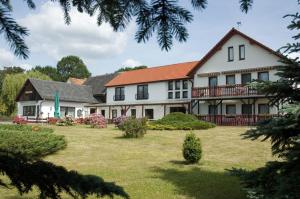 ein großes weißes Haus mit einem Hof in der Unterkunft Hotel Zur Wildtränke in Spremberg