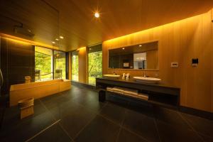a large bathroom with two sinks and a tub at Hakuba Jolie Maison by Jade Villa in Hakuba